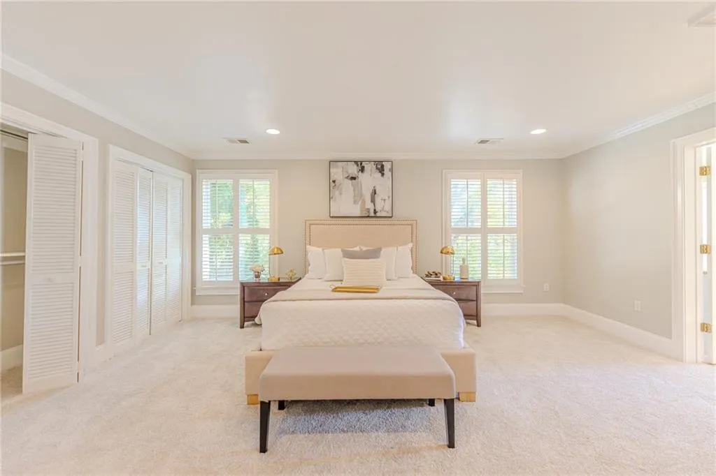 Master Bedroom with multiple closets, carpet flooring, ornamental molding, multiple windows, and recessed lighting