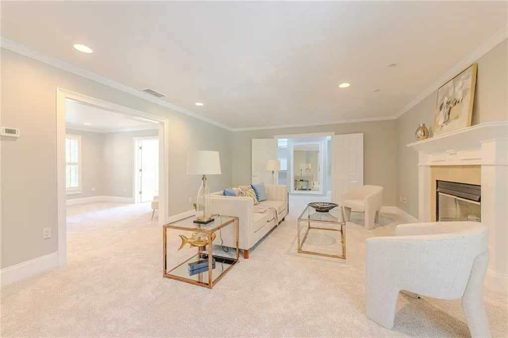 Master Bedroom Living area featuring crown molding, light colored carpet, recessed lighting, and a tiled fireplace