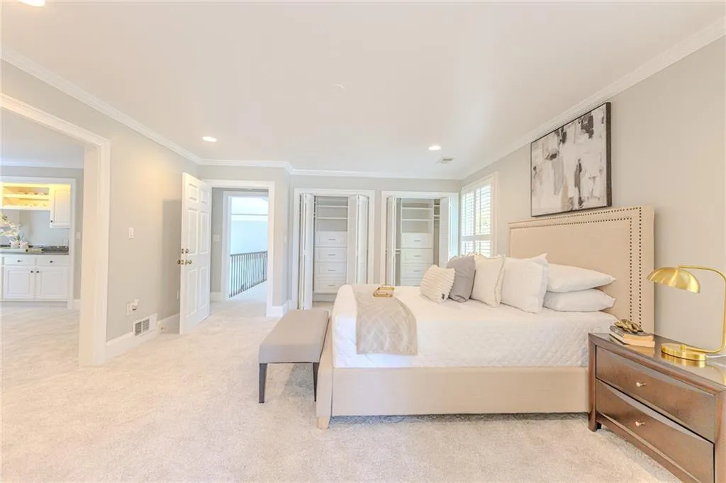 Master Bedroom featuring multiple closets, ornamental molding, light colored carpet, and recessed lighting