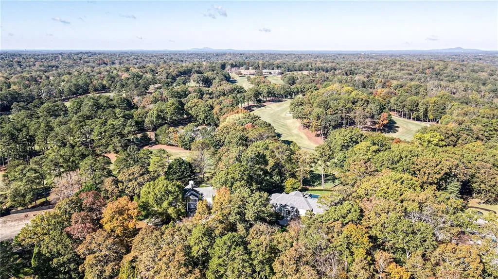 Aerial view of property's location with a heavily wooded area