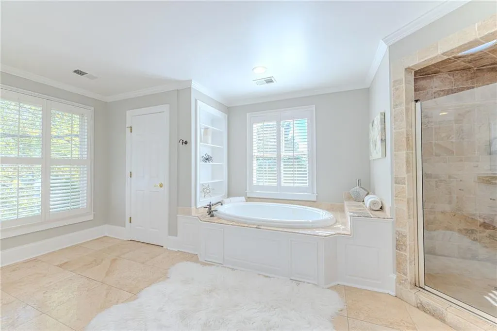 Full Master bathroom with a garden tub, crown molding, a stall shower, and light tile patterned flooring