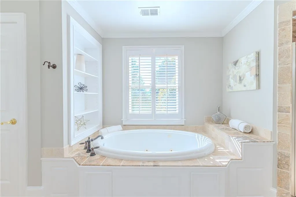 Bathroom with a whirlpool tub and crown molding