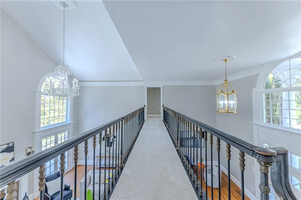 Primary suite opens to an interior balcony with views of the grand living space