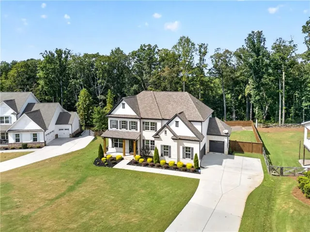 Two-story residence featuring a light-toned brick exterior, dark-toned roof, and a covered front entry with columns