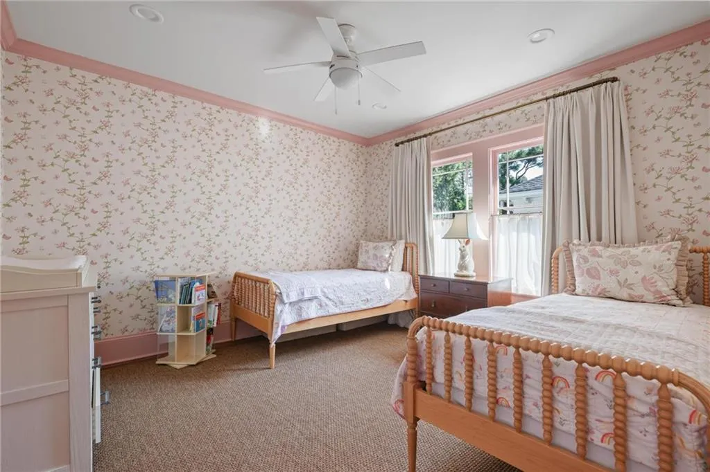 Bedroom with ornamental molding, carpet flooring, wallpapered walls, and ceiling fan