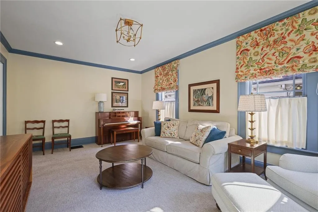 Carpeted living area featuring ornamental molding and recessed lighting