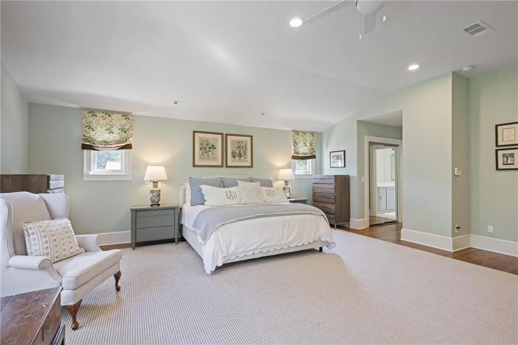 Bedroom with multiple windows, vaulted ceiling, ceiling fan, recessed lighting, and wood finished floors
