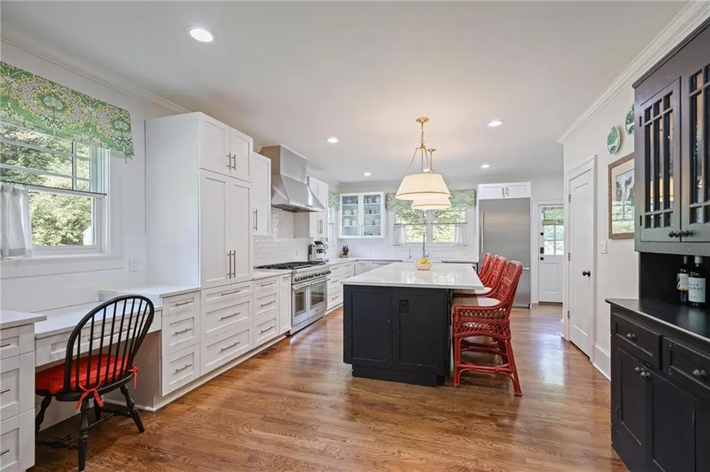 Kitchen featuring pendant lighting, dark wood-style flooring, decorative backsplash, crown molding, and dark cabinetry