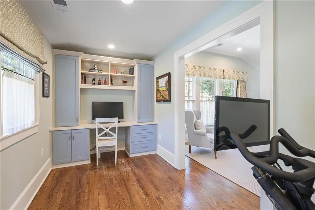 Office area with dark wood-style floors, built in desk, and recessed lighting