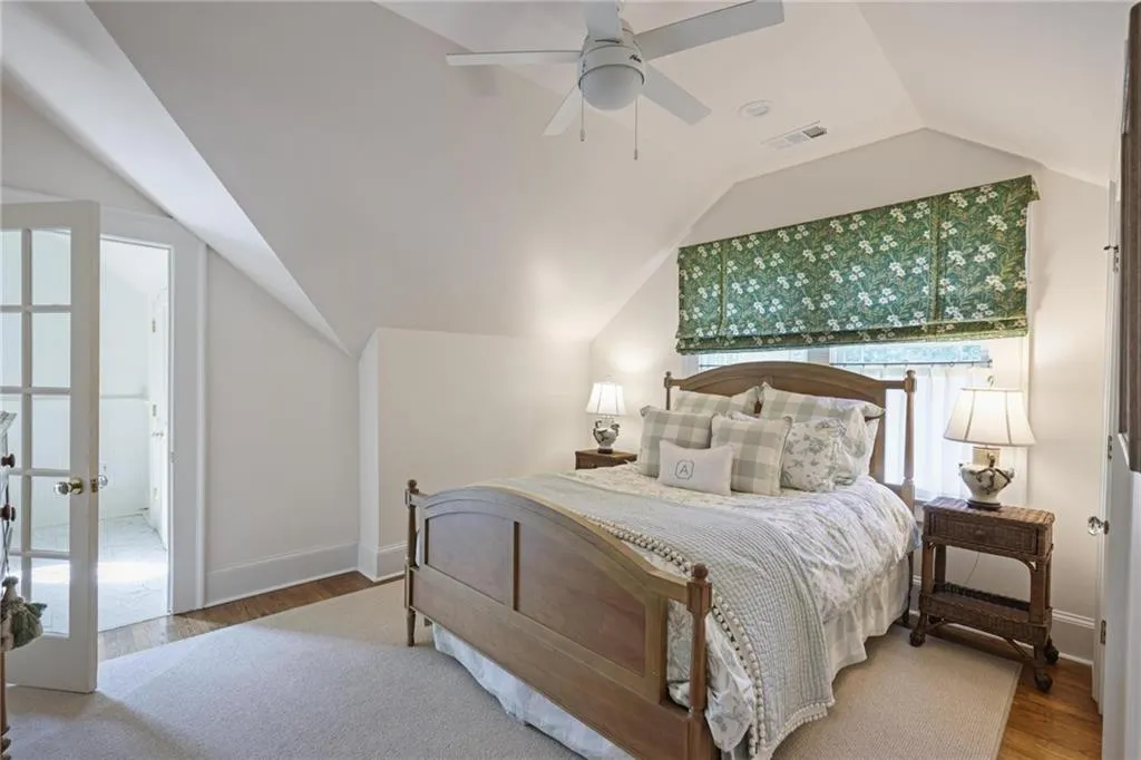 Bedroom with wood finished floors, lofted ceiling, ceiling fan, and french doors