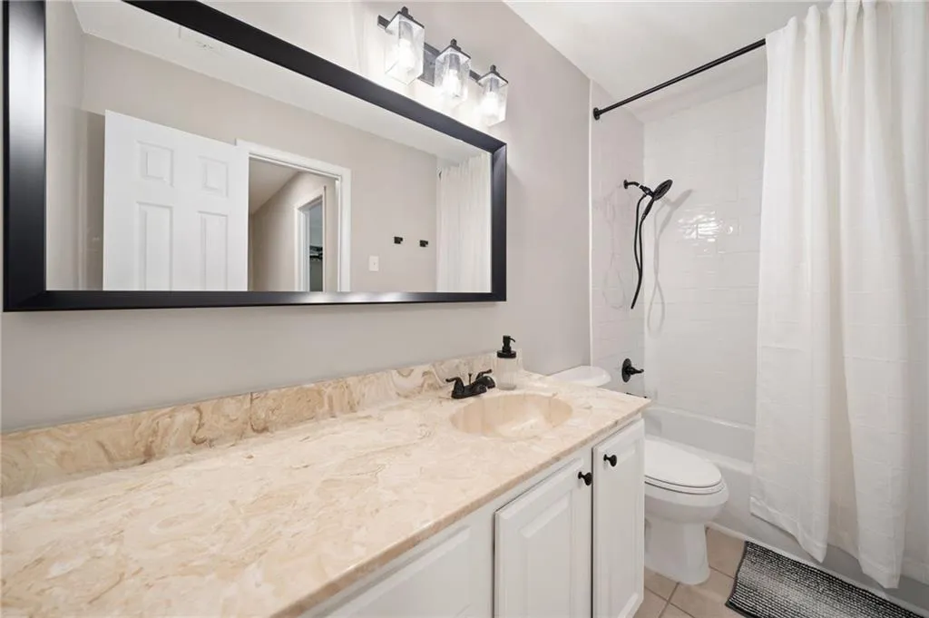 Full bathroom featuring tile patterned flooring, shower / tub combo, vanity, and toilet