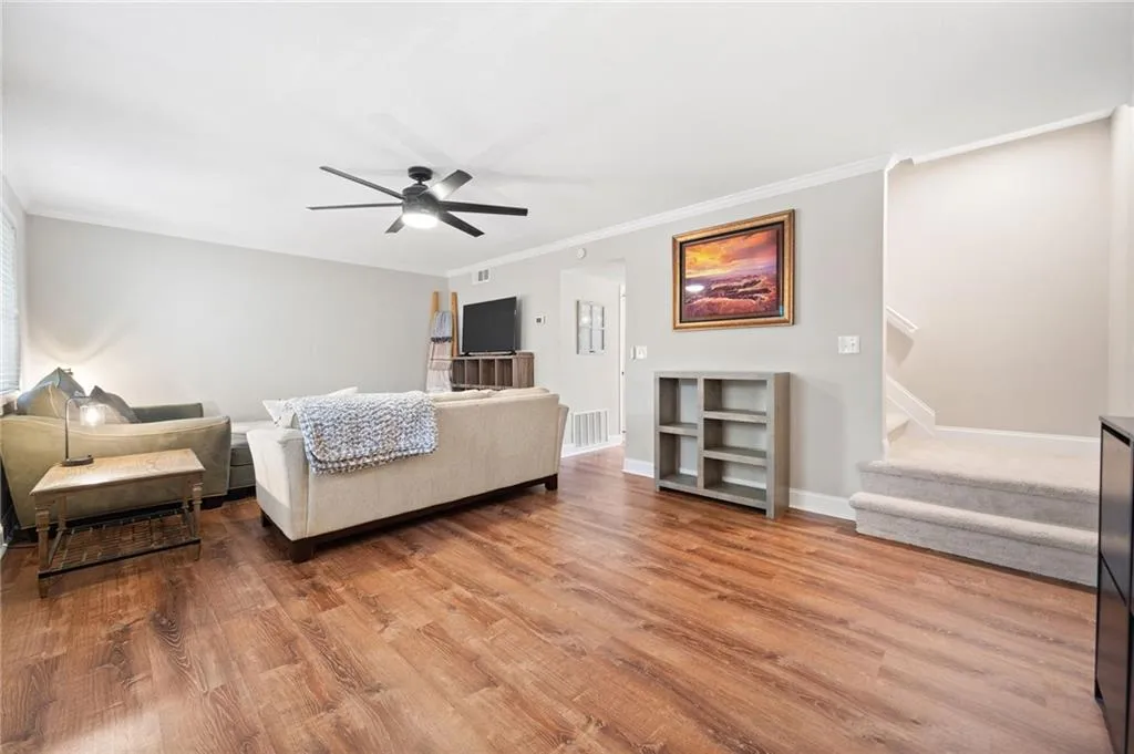Bedroom with hardwood / wood-style floors, ceiling fan, and crown molding