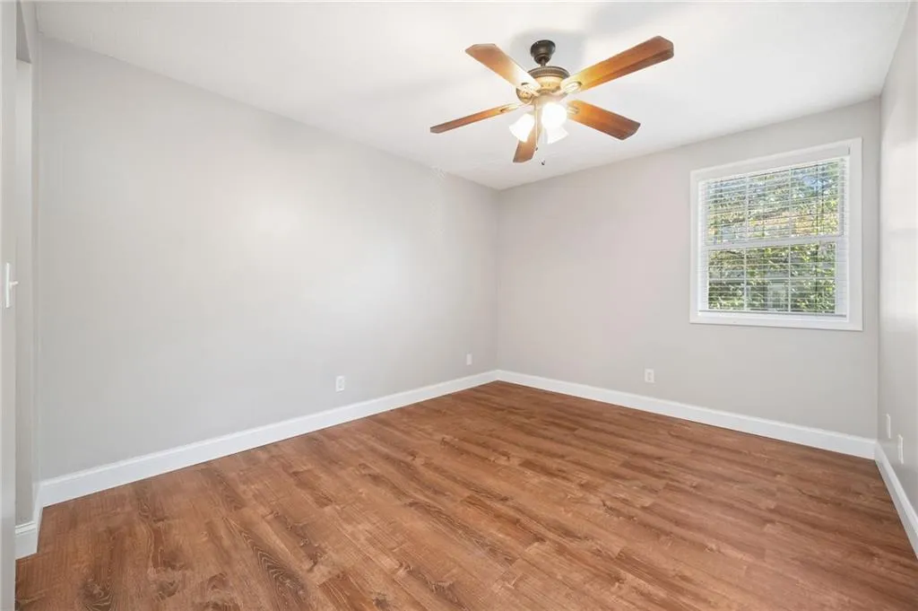 Spare room with hardwood / wood-style floors and ceiling fan