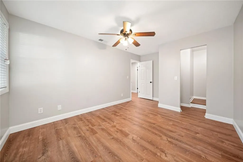 Unfurnished bedroom with ceiling fan and wood-type flooring