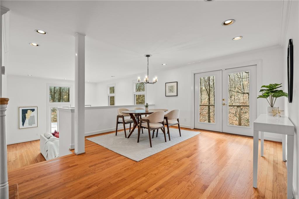 Light-filled dining area featuring hardwood floor and French doors opening to deck.