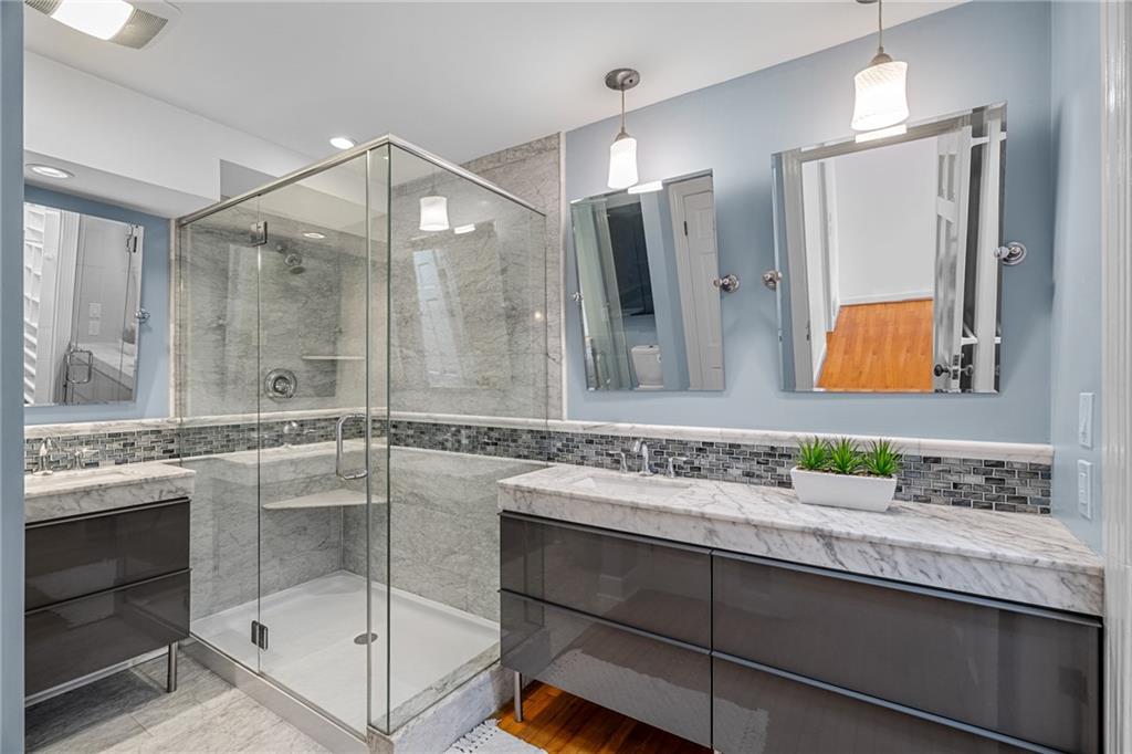 Bathroom featuring a frameless enclosed shower and double vanity