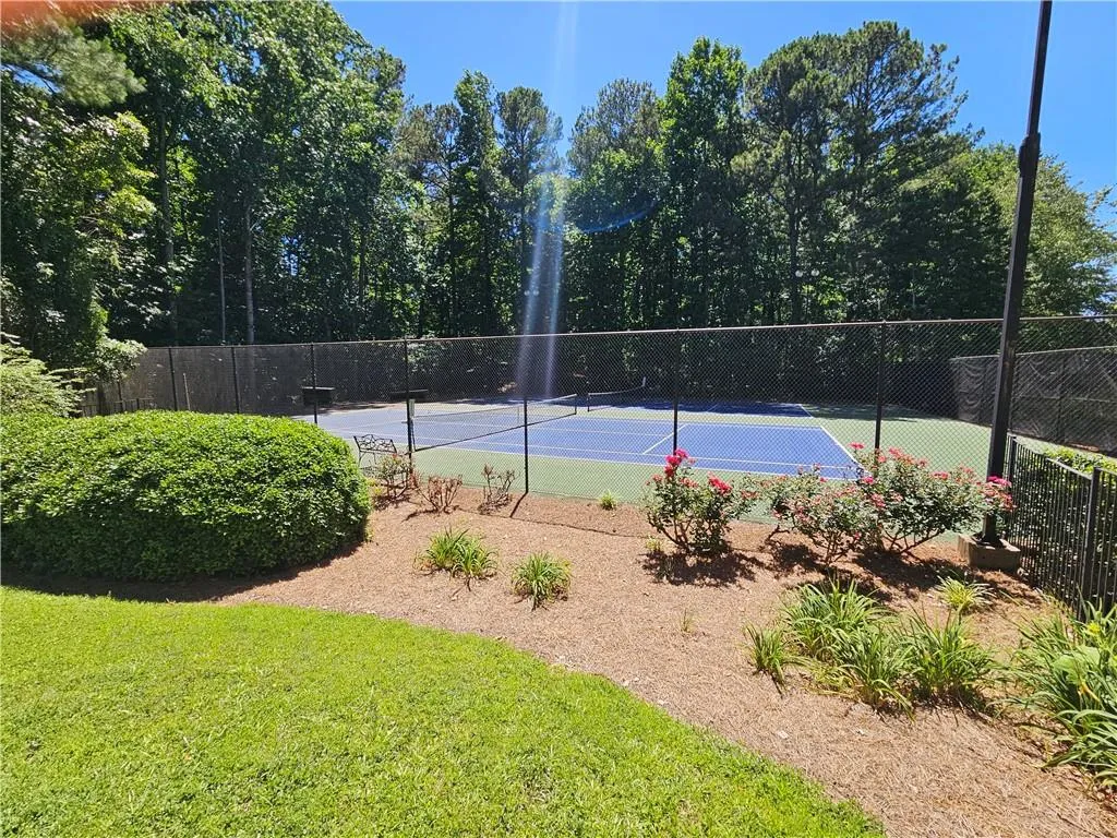View of sport court featuring a lawn