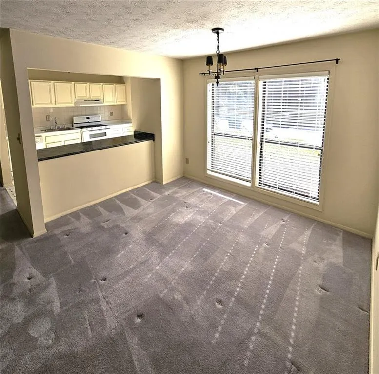 Kitchen with white range, plenty of natural light, and tasteful backsplash