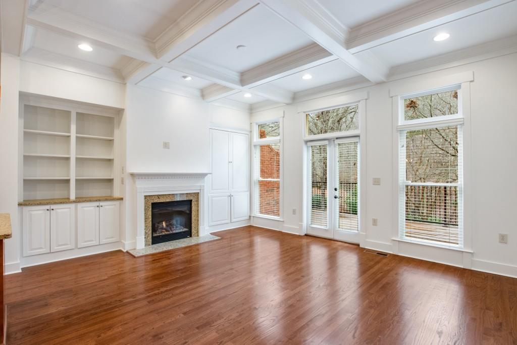 Off the kitchen you've got a massive living room with coffered ceiling, gas fireplace flanked by custom built-ins, and access to the huge back deck.