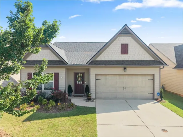 Single-story residence featuring a two-car garage, a concrete driveway, and a front entry with a dark-paneled door