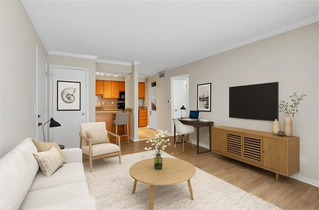 Living area with light wood finished floors and crown molding