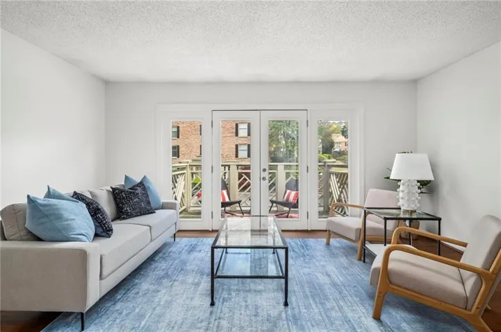 Bright living space featuring French doors opening to an outdoor balcony