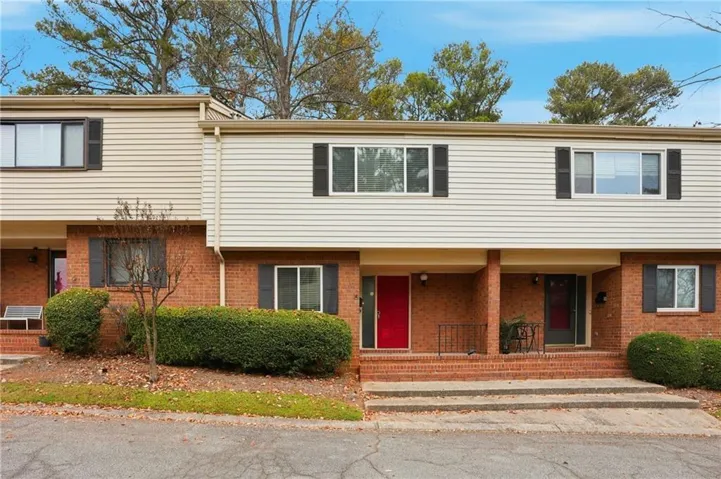 Brick and siding exterior featuring shutters and a covered entry