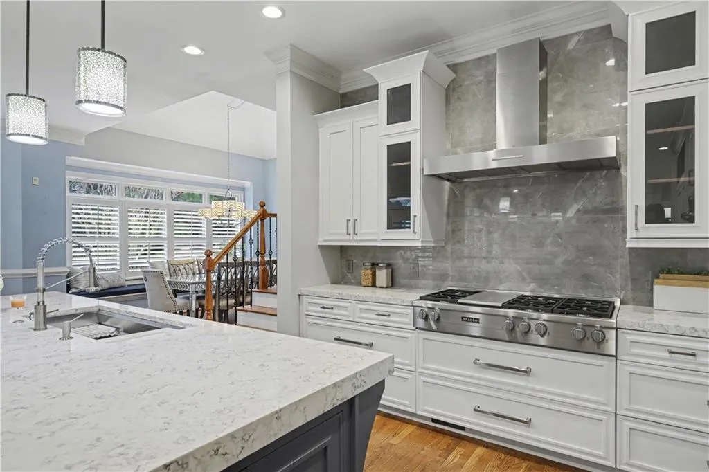 Updated kitchen anchors the main level with custom cabinetry, high-end appliances, two dishwashers, an oversized island, and a breakfast room with coffee bar that flows seamlessly into the keeping room.