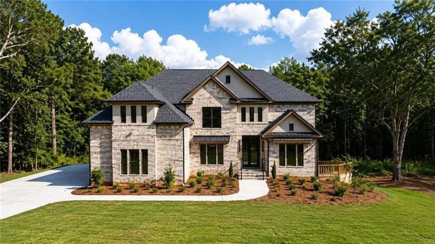 Stately two-story residence featuring a stone and brick exterior with multiple gabled rooflines and a dark asphalt shingle roof
