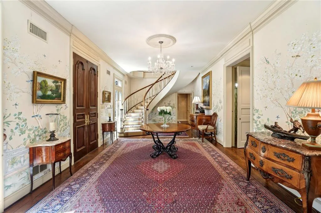 Foyer with visible vents, an inviting chandelier, stairway, and wallpapered walls