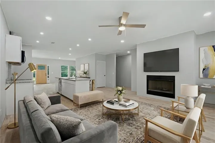 Open-concept living area featuring wood-finish flooring, recessed lighting, and a modern ceiling fan