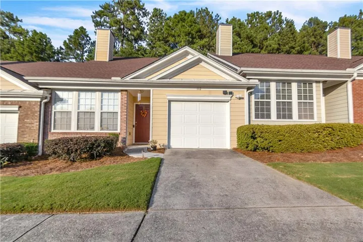 Siding exterior with brick accents, attached garage, and mature landscaping