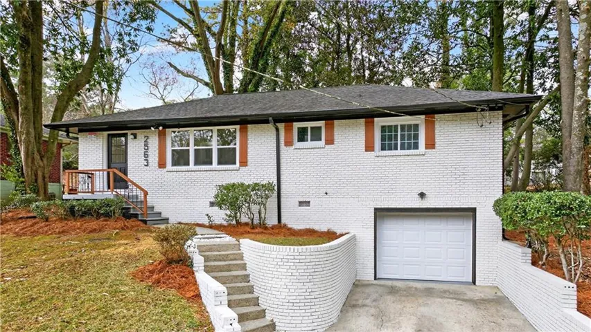 White brick exterior with a black roof and wood-tone shutters