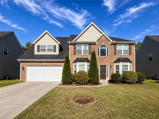 Brick and siding exterior featuring a two-car garage