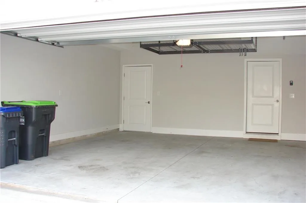 Garage featuring baseboards and a garage door opener