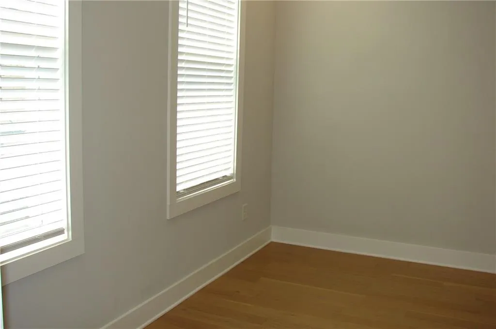 Unfurnished primary bedroom with wood-type flooring.