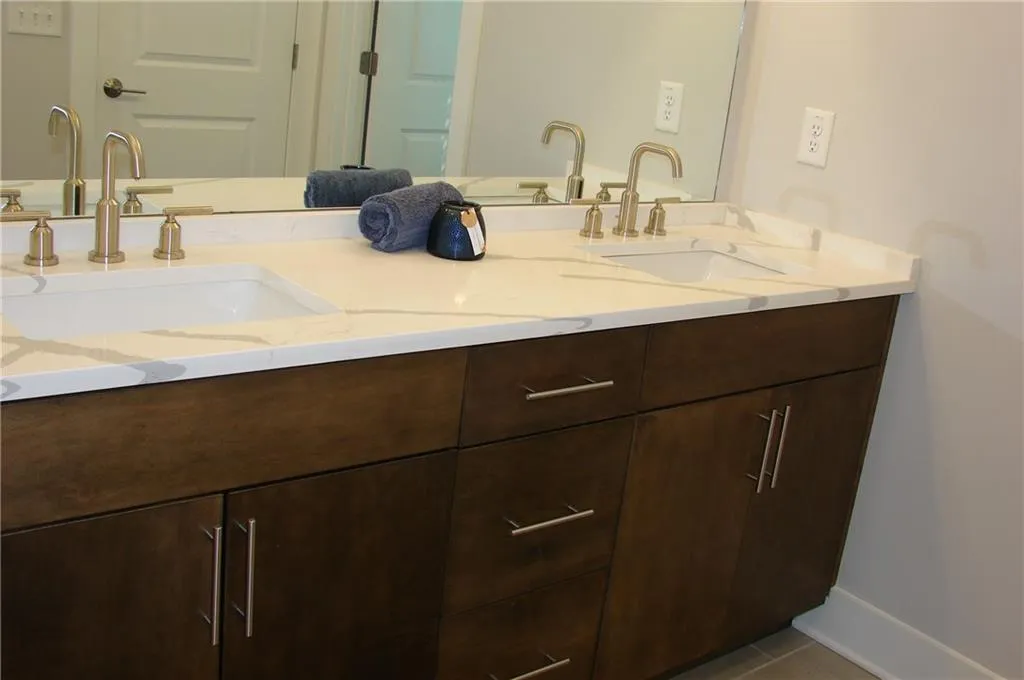 Primary bathroom featuring double vanity and light tile patterned flooring