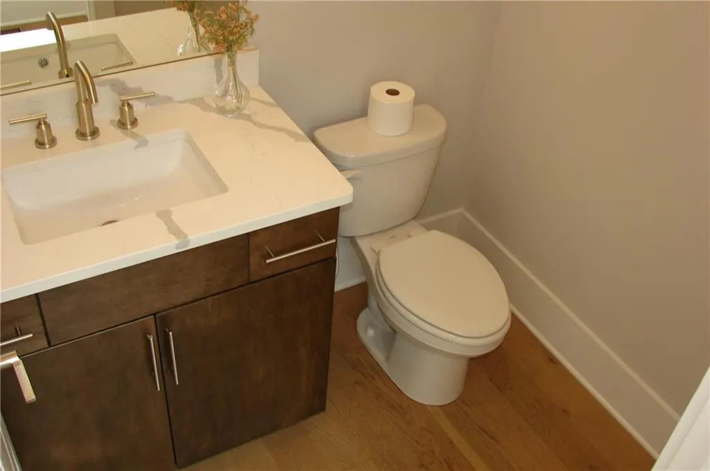 Powder room on main level featuring vanity and light wood finished floors