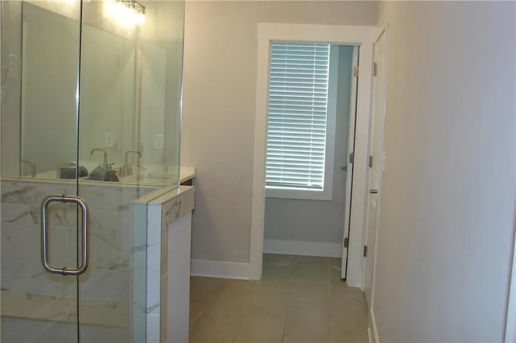 Primary bathroom featuring vanity, a stall shower, and light tile patterned floors