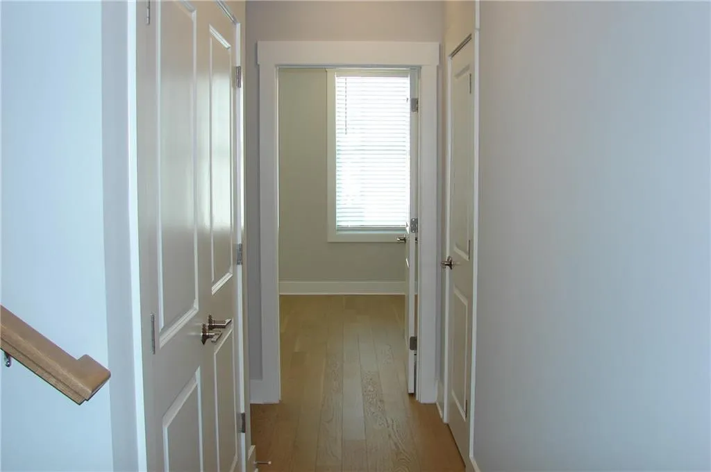 Hallway with light wood-style flooring.