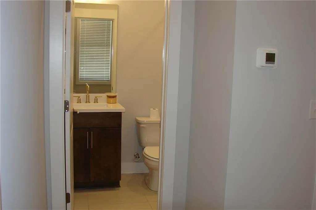 Lower-level 3rd bedroom/office with view to bath and light tile patterned floors