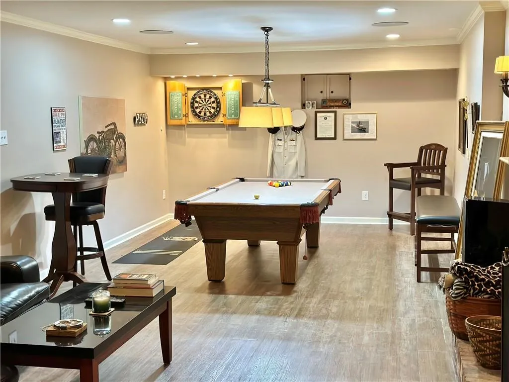 Recreation room with light hardwood / wood-style floors, ornamental molding, and pool table