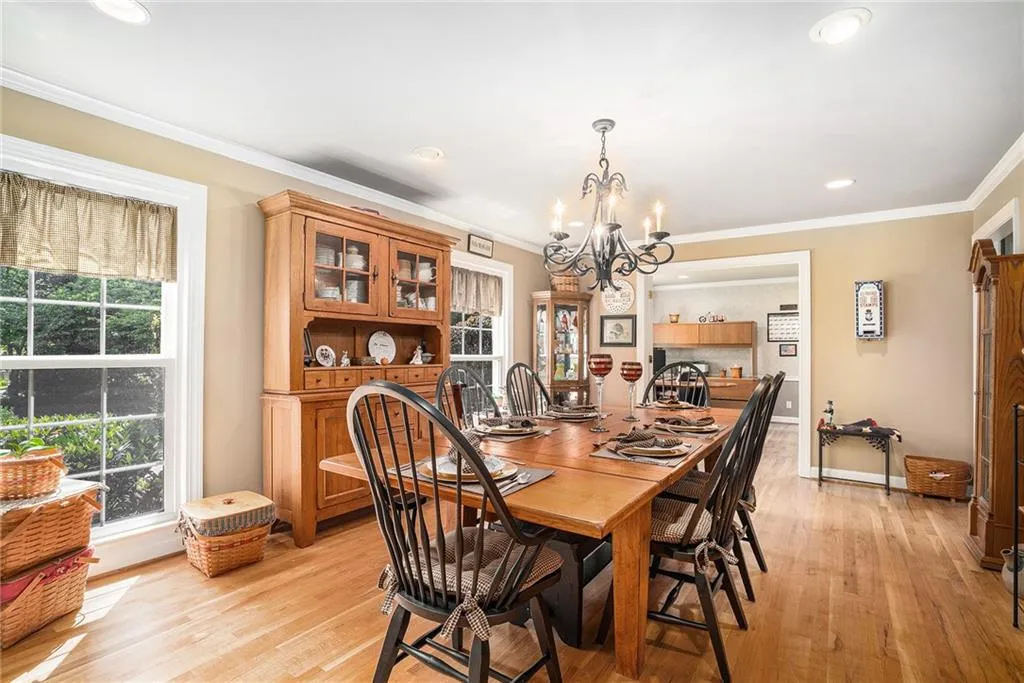 Dining area with light hardwood / wood-style floors, ornamental molding, and a chandelier