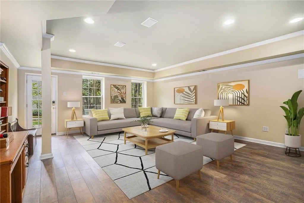 Living room with ornate columns, hardwood / wood-style flooring, and crown molding Virtually Staged