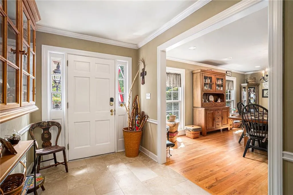 Foyer entrance featuring crown molding and light hardwood / wood-style flooring