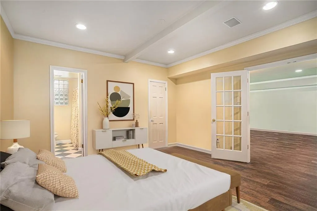Bedroom with ensuite bath, ornamental Virtually staged molding, beam ceiling, and hardwood / wood-style flooring
