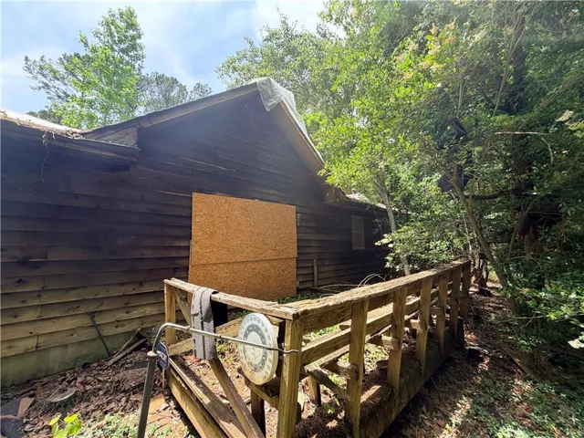 Wood-sided exterior featuring an exposed gable roofline and a partial wooden railing