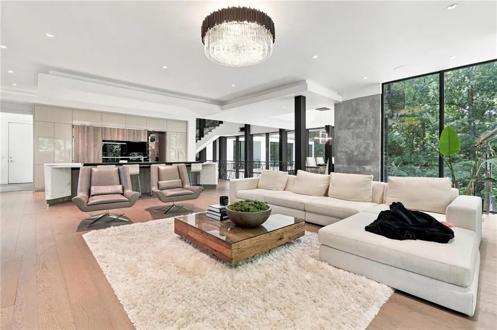 Wood-finish flooring, recessed lighting, and a crystal chandelier complement the full-height window panels