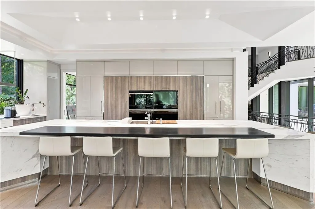 Spacious kitchen with a central island, integrated appliances, recessed lighting, and a multi-level ceiling