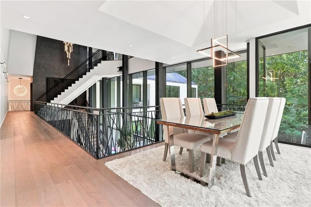 Wood-finish flooring leading to an open-concept dining area with expansive floor-to-ceiling windows
